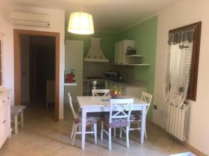 een keuken met een witte tafel en stoelen. bij Appartamento Giulia in Muravera