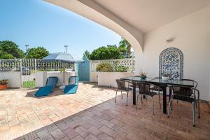 eine Terrasse mit einem Tisch, Stühlen und einem Sonnenschirm in der Unterkunft BeGuest Vale de Lobo 932 Villa in Almancil