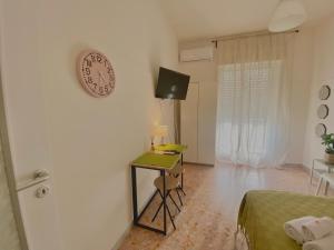 una camera da letto con un orologio a muro e una scrivania di Guest House Service Modugno - ZONA INDUSTRIALE a Modugno