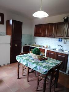 a kitchen with a table with a bowl of greens on it at Casa Vacanze Baia Verde in Trabia