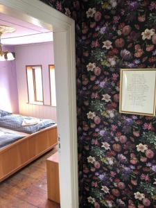 1 dormitorio con un mural floral en la pared y 1 cama en Retro-Sonnenbring B&B, en Sønderborg
