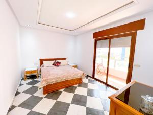a bedroom with a bed and a checkered floor at Visit Oued Laou - Florencia in Oued Laou