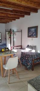 1 dormitorio con 1 cama, mesa y silla en LA PALMERA en Maipú
