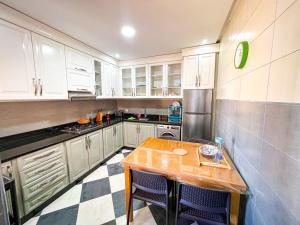 a kitchen with white cabinets and a wooden table at Visit Chamal - Florencia in Oued Laou