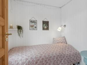 ein Schlafzimmer mit einem Bett und einem Stuhl in der Unterkunft Holiday Home Kajo - 800m from the sea in NE Jutland by Interhome in Hals
