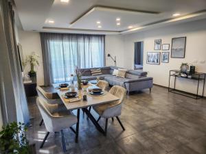 uma sala de estar com uma mesa e um sofá em Villa Capris apartments em Koper