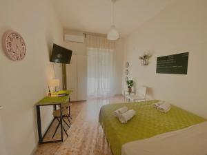 una camera con letto, scrivania e orologio di Guest House Service Modugno - ZONA INDUSTRIALE a Modugno