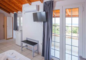 a room with a bed and a tv and a window at Kontogoni Rooms in Elafonisos
