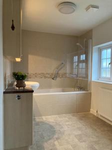 a bathroom with a bath tub and a sink at Yew Tree House in Woodstock