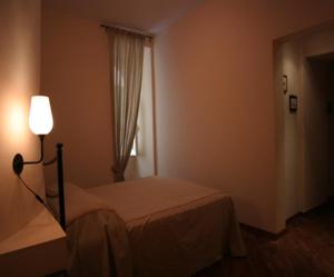 a bedroom with a bed and a lamp and a window at B&B Vicolo Vecchio in Terracina