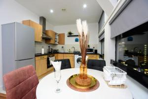 a kitchen with a table with a vase on it at Apartment In Manchester City in Manchester