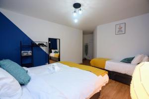 two beds in a room with blue and white at Apartment In Manchester City in Manchester