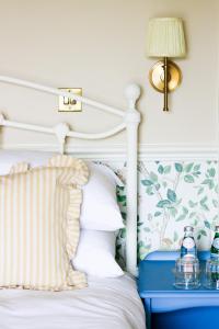 a bedroom with a white bed with a blue end table at Fleur de Lys Bampton in Bampton