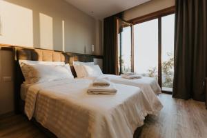 克鲁亚Hotel Kroi near castle entrance castle and town view的一间卧室，有两张床，床上有毛巾