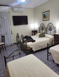 ein Hotelzimmer mit 2 Betten und einem Flachbild-TV in der Unterkunft Maison Manni' B&B in Soverato Marina