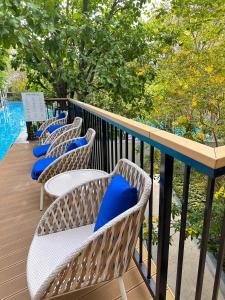 華欣的住宿－Pool Access La Habana HuaHin Managed By Asiabb，阳台上的一排带蓝色枕头的椅子