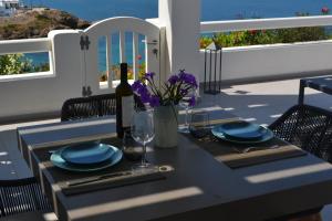 un tavolo con piatti blu e una bottiglia di vino di Nautilus Apartments a Lisso (Lipsoi)