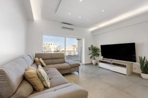 a living room with a couch and a flat screen tv at Apartamento Mar e Sol in Portimão