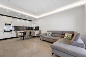 a living room with a couch and a table and a kitchen at Apartamento Mar e Sol in Portimão
