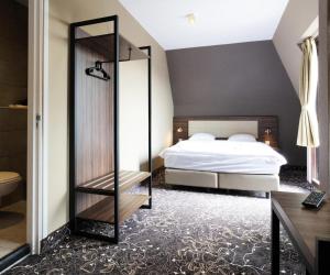 een slaapkamer met een bed en een spiegel bij Amsterdam Lake Hotel in Badhoevedorp