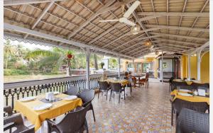 a dining room with tables and chairs and a train at Anthy’s à la Campagne in Benaulim