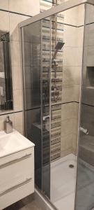 um chuveiro com uma porta de vidro na casa de banho em Apartament nad Jeziorem w Olecku em Olecko