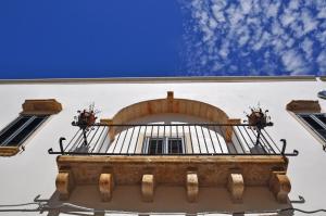 a building with a balcony with two windows at Palazzo Vaglio in Alliste