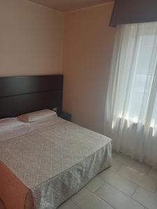 1 dormitorio con cama y ventana en Hotel Porta Rivera Plesso Stazione, en LʼAquila