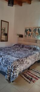 a bedroom with a leopard print bed in a room at LA PALMERA in Maipú