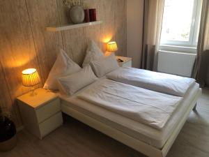 a bedroom with a bed with white sheets and pillows at Holiday Home Knapp by Interhome in Breisach am Rhein