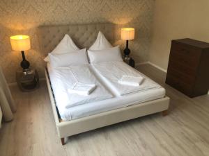 a bed with white sheets and pillows and two lamps at Holiday Home Knapp by Interhome in Breisach am Rhein