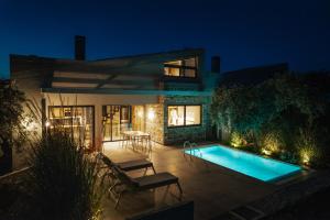 a house with a swimming pool at night at olive blue thassos luxury villas in Astris