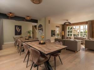 a dining room with a large wooden table and chairs at Holiday Home Het Landhuis by Interhome in Losser +33 photos