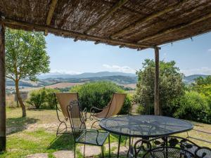 een tafel en stoelen op een patio met uitzicht bij Holiday Home Le Calle by Interhome in Cinigiano