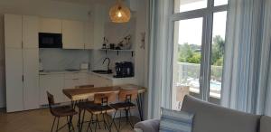 een keuken met een tafel en stoelen in een kamer bij Śliczny Apartament Happy 46 Hampton - tuż przy plaży in Sianozety