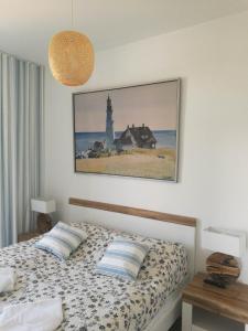 a bedroom with a bed with a picture on the wall at Apartament Happy 46 Hampton z klimatyzacją - tuż przy plaży!!! in Sianozety