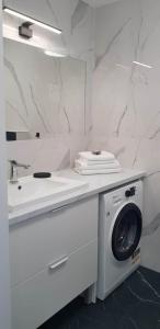 a white bathroom with a washing machine under a sink at Apartament Happy 46 Hampton z klimatyzacją - tuż przy plaży!!! in Sianozety