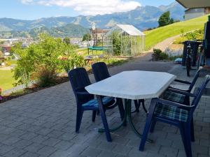 une table et des chaises sur une terrasse avec des montagnes en arrière-plan dans l'établissement Apartment Luxenweid by Interhome, à Reichenburg