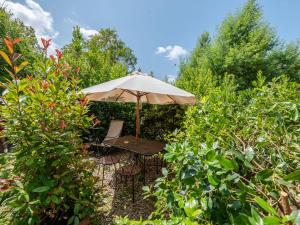 einen Regenschirm und einen Stuhl in einem Garten in der Unterkunft Holiday Home Olinto by Interhome in Cinigiano
