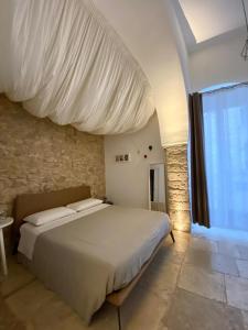 ein Schlafzimmer mit einem Bett mit einem weißen Baldachin in der Unterkunft Altrelli B&B in Corato