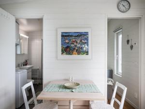 uma sala de jantar com uma mesa e um relógio na parede em Holiday Home Solbacken by Interhome em Alingsås