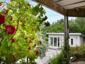 een uitzicht op een huis vanuit een tuin met rode bloemen bij Holiday Home Solbacken by Interhome in Alingsås