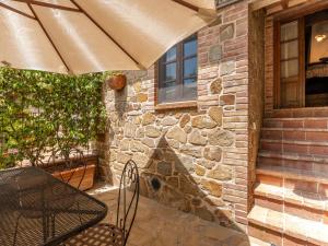 a patio with a table and an umbrella at Holiday Home Carola by Interhome in Cinigiano