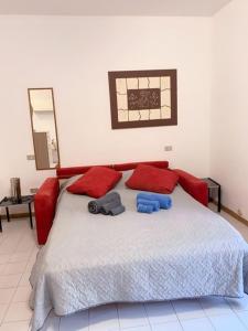 um quarto com uma cama grande e almofadas vermelhas em GardenHouse em Cagliari