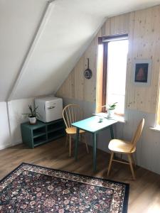 a dining room with a table and chairs and a window at Retro-Sonnenbring B&B in Sønderborg
