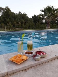 ein Tablett mit Obst und Getränken neben dem Pool in der Unterkunft Villa Les palmiers in Besse-sur-Issole