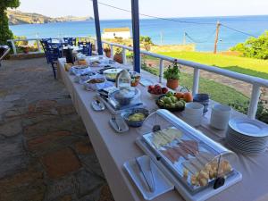 a table with food on it with the ocean in the background at Sunset Hotel in Agios Ioannis Kaspaka