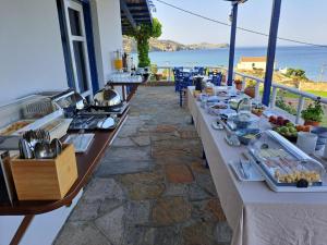 a buffet table with food on a balcony with the ocean at Sunset Hotel in Agios Ioannis Kaspaka
