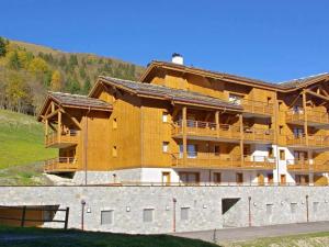 a large wooden building with a fence in front of it at Appartement Valmorel, 4 pièces, 8 personnes - FR-1-291-833 in Valmorel
