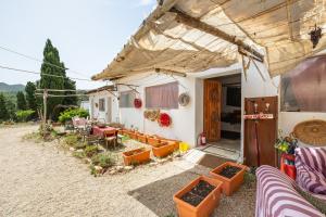 une maison avec une terrasse dotée de tables et de chaises dans l'établissement La Casetta Rurale - In Our Garden, à Capitana